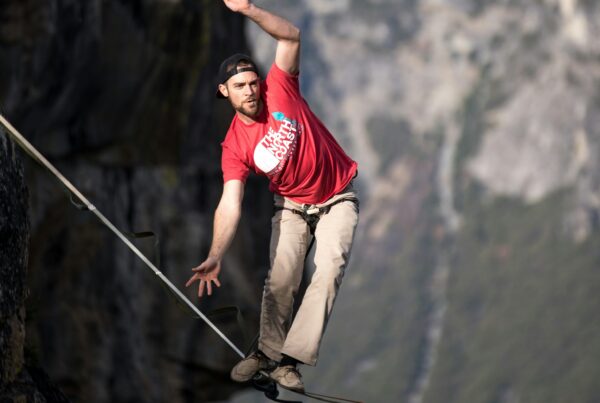 Man balancing on a tightrope over a canyon. Balancing stability and change in a business can feel like walking on a tightrope.